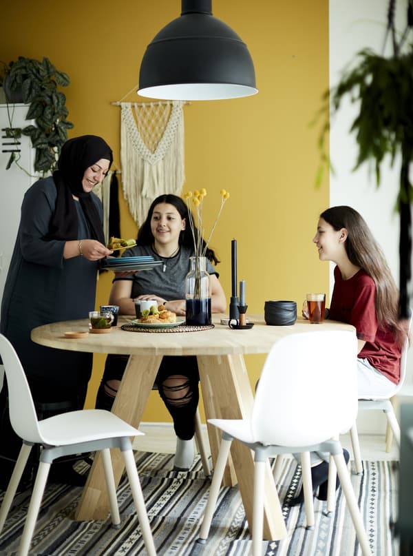 La famille d’Aysu en train de prendre le petit déjeuner à la table de salle à manger dans une cuisine jaune.