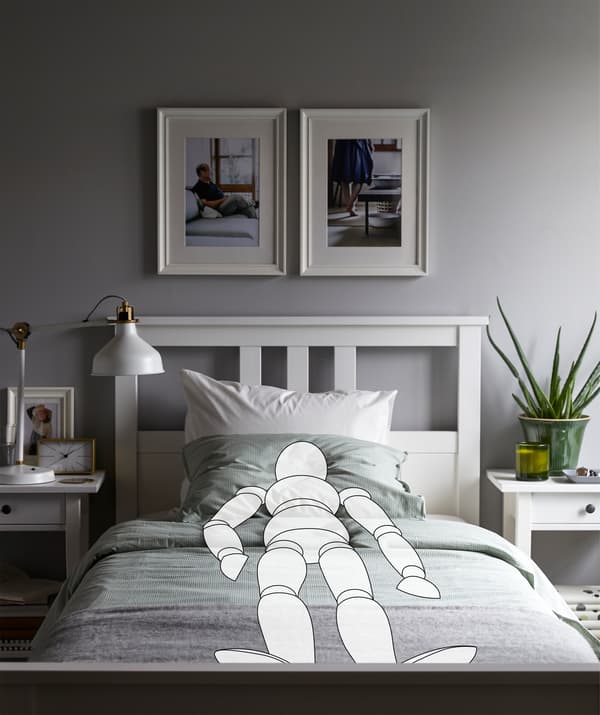 La sagoma di un manichino coricato in posizione dritta e simmetrica in una camera da letto molto ordinata - IKEA