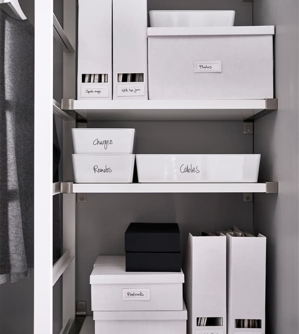 Labeled white boxes and magazine holders keeping things organised on three different shelves.