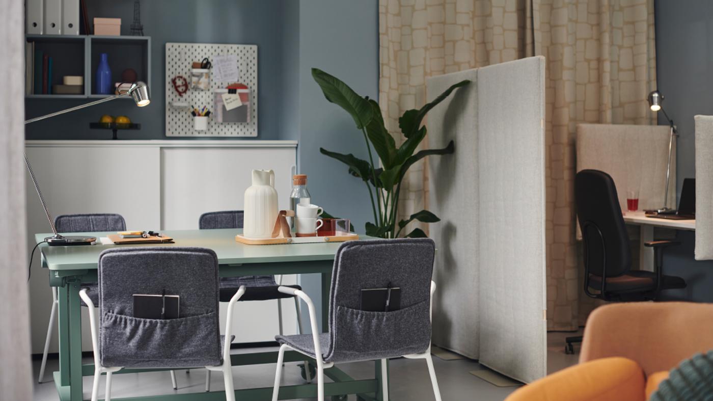LÄKTARE conference chairs are placed around a MITTZON foldable table with castors in an office space with blue walls.