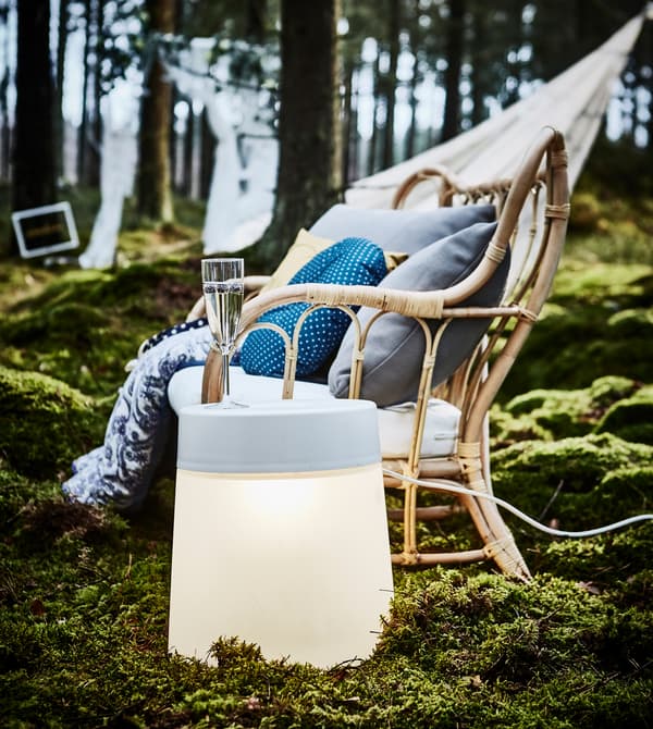 Lampe-tabouret utilisée comme table d’appoint près d’un fauteuil, dans un coin détente aménagé pour une fête de noces en forêt