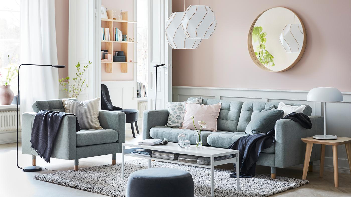 LANDSKRONA light green sofa, SJÖPENNA pendant lamps and black YPPERLIG standing lamps in a pink walledl living room.