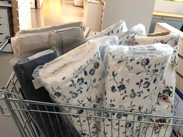 Látky IKEA nasklídané ve vozíku, které byly věnovány na ušití roušek.