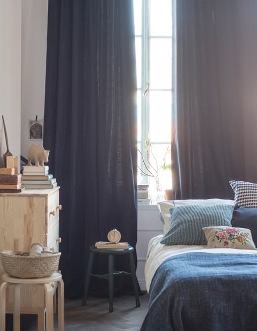 Le bleu et le blanc dominent le choix des tissus de la chambre à coucher. Les rideaux vont du sol au plafond.