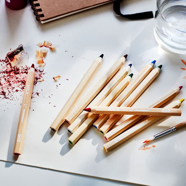 Le dessus d’un bureau blanc avec des crayons de couleur et des copeaux de crayon.
