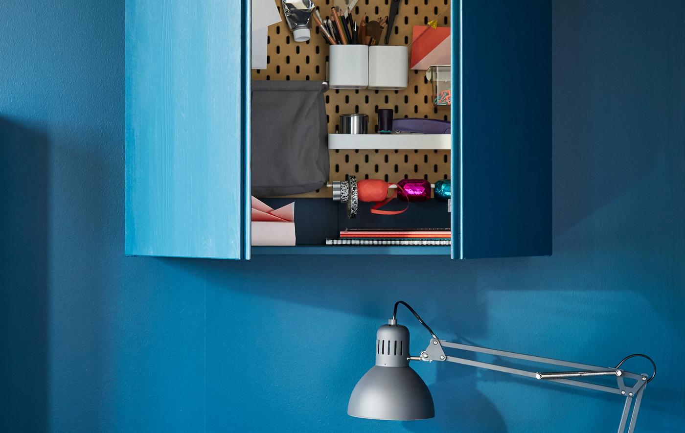 Le panneau perforé SKÅDIS en fibres de bois verni de chez IKEA existe en différentes dimensions. Accrochez-y juste les accessoires qu’il vous faut, comme des pots en acier thermolaqué blanc, des crochets et des tablettes, pour ranger ciseaux, agrafeuses et stylos.