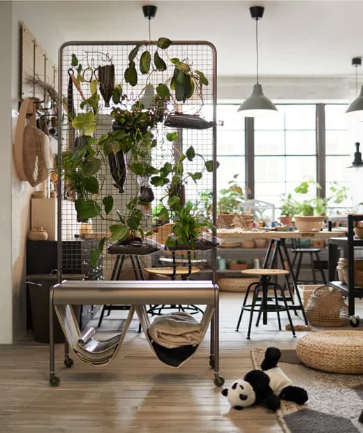 Le paravent VEBERÖD est couvert de plantes et il sépare l’espace bureau du coin jeu dans une pièce lumineuse où l’acier noir et le bois clair s’harmonisent joliment.