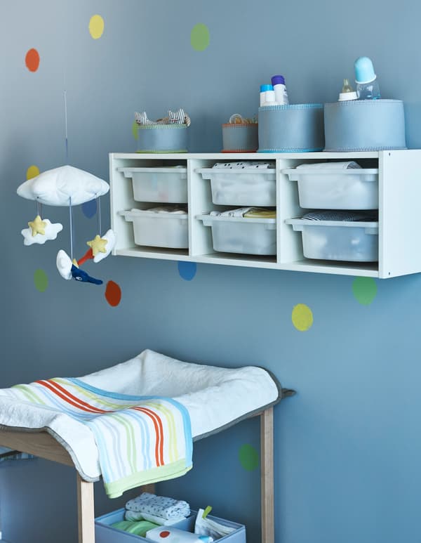 Le rangement mural placé au-dessus de la table à langer est idéal au début… Plus tard, il suffit de descendre la structure au niveau du sol et votre petite merveille pourra y ranger ses jouets.