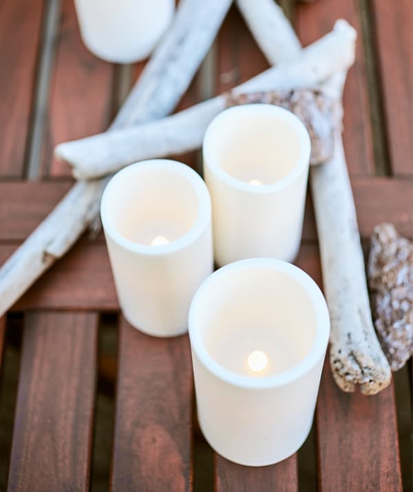 LED block candles on a wooden table with driftwood.