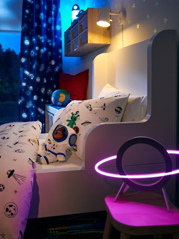 LED lampička AFTONSPARV před postelí s povlečením AFTONSPARV. 
