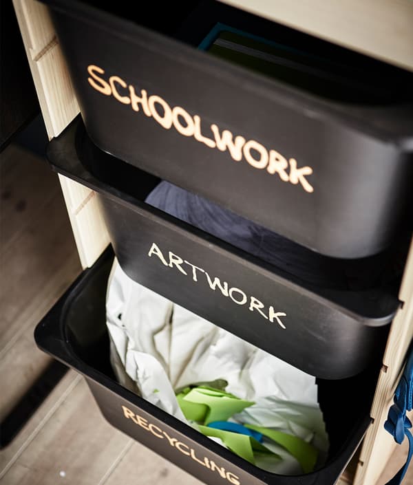 Les boîtes TROFAST sont étiquetées et servent de rangement aux travaux scolaires, aux travaux artistiques et au papier à recycler.