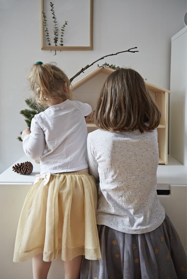 Les enfants jouent avec leur maison de poupées.