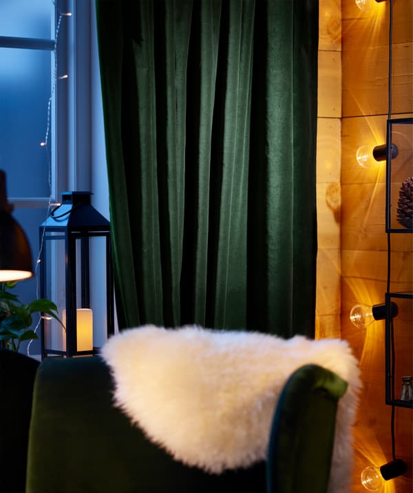 Les rideaux en coton vert foncé IKEA SANELA sont faciles à accrocher et à tirer au moment du coucher.