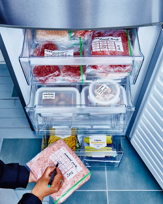 Les tiroirs du congélateur sont ouverts et présentent des aliments bien regroupés, emballés et identifiés.