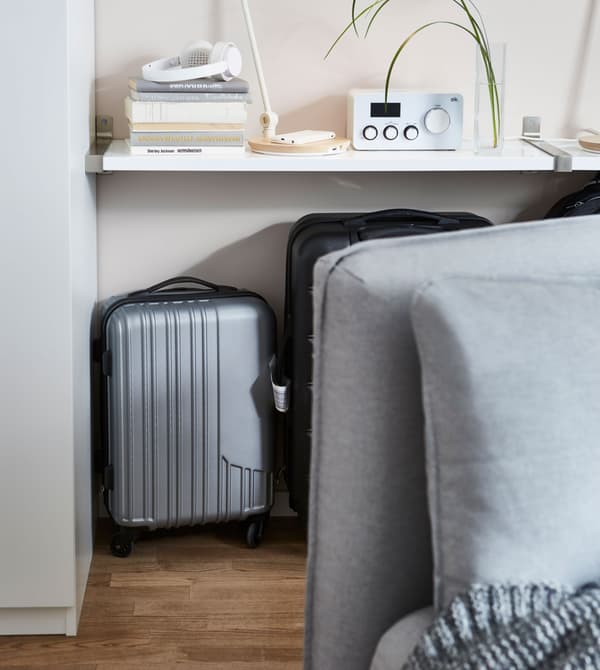 Les valises sont rangées derrière le canapé.