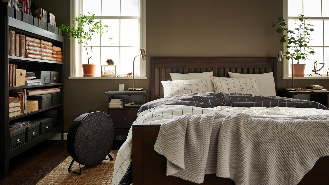 Letto marrone scuro IDANÄS con biancheria VITKLÖVER a quadri su un tappeto a tessitura piatta LOHALS naturale e un purificatore d'aria nero rotondo - IKEA.