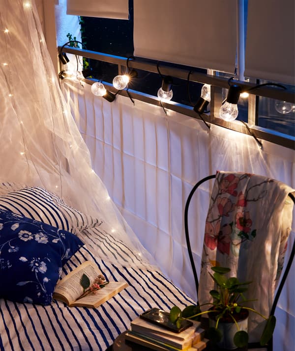 Letto vicino alla ringhiera ricoperta dal separé per balcone DYNING e tende a rullo oscuranti a scomparsa - IKEA