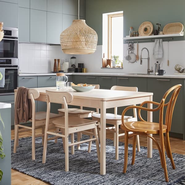 Light wood chair with a curved seat and backrest in a living room setting.				