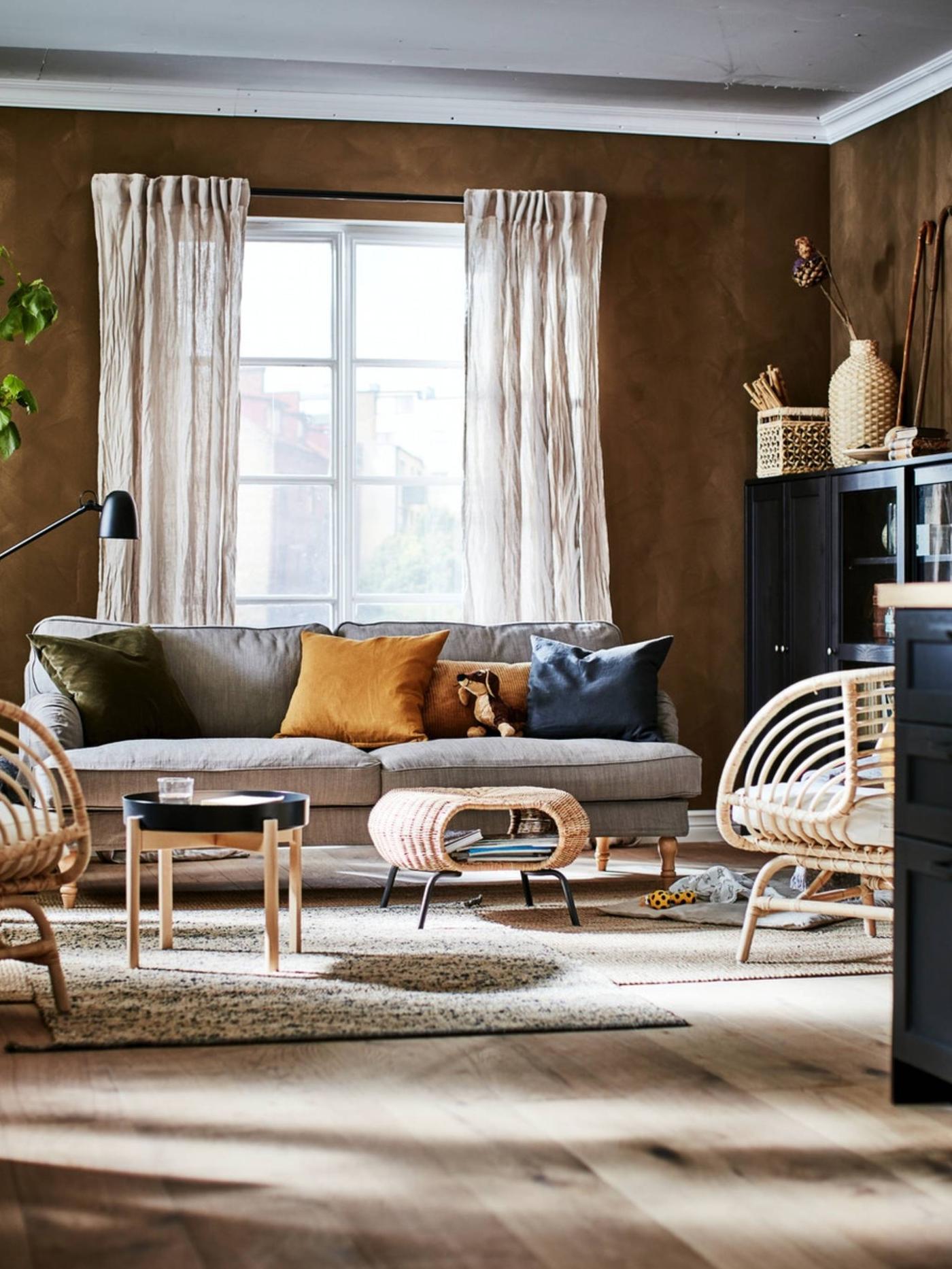 Living room in an earthy-shades color scheme with decorations, storage, BUSKBO armchairs, a sofa, side table and footstool.