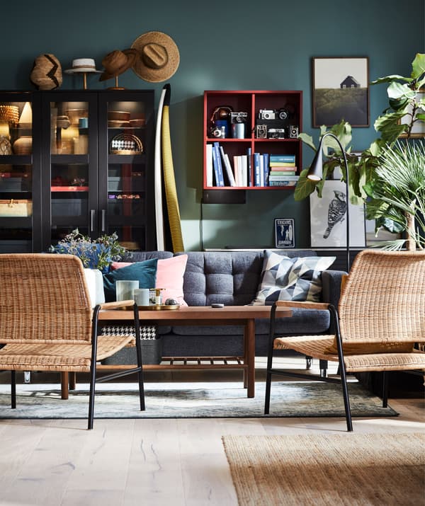 Living room with seating around a coffee table, a backdrop of a wall with a lot of open and display storage.