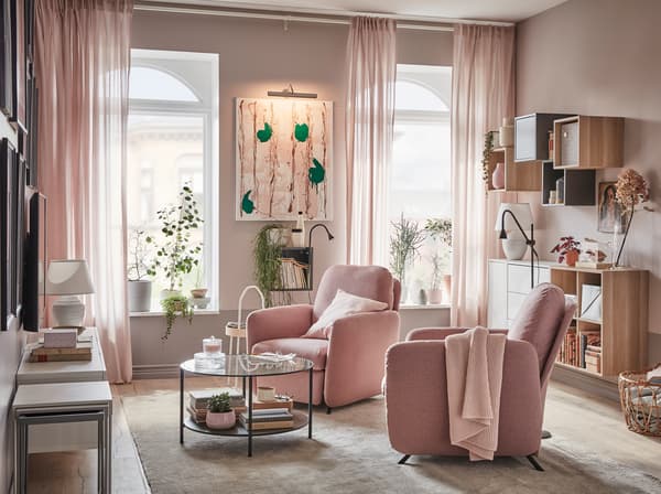 Living room with two EKOLSUND recliners in GUNNARED light brown-pink covers, in front of windows with light streaming in.