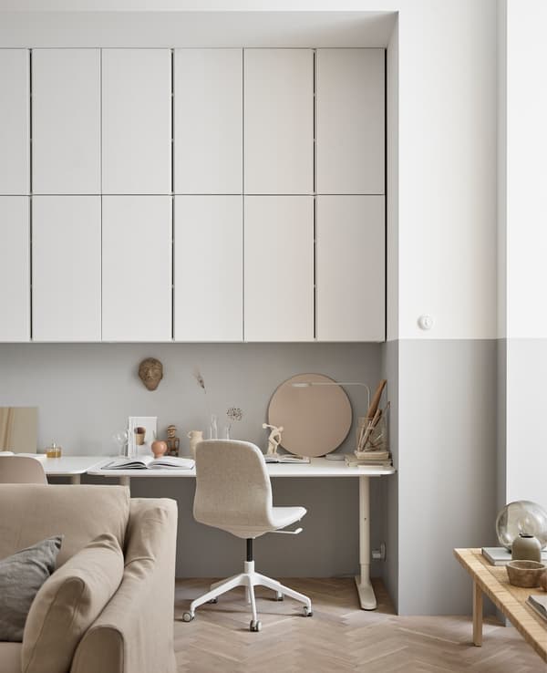 Lots of overhead wall cabinets create storage for a workspace in this large living room.