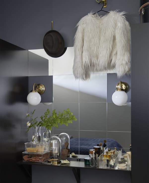 Lots of square mirrors mounted on a bedroom wall to create a unique vanity.