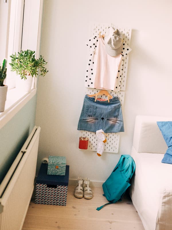 L'outfit per la scuola pronto per il giorno dopo, compresi lo zaino, i calzini e le scarpe, è appeso a un pannello portaoggetti SKÅDIS - IKEA