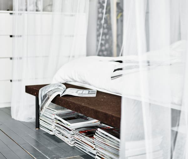 Magazines stacked underneath a cork bench at the end of the bed. What’s your dream bedroom?