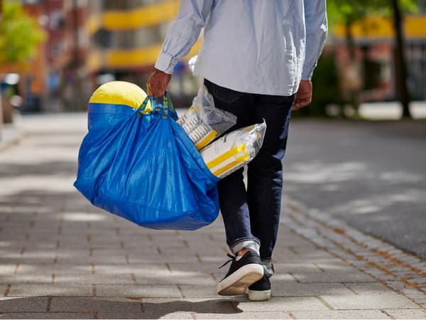 man holding blue FRAKTA bag