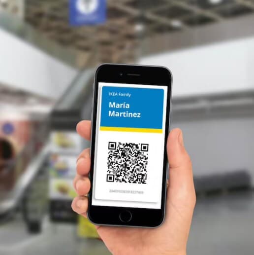 Mano sosteniendo teléfono celular con un código QR en la pantalla.