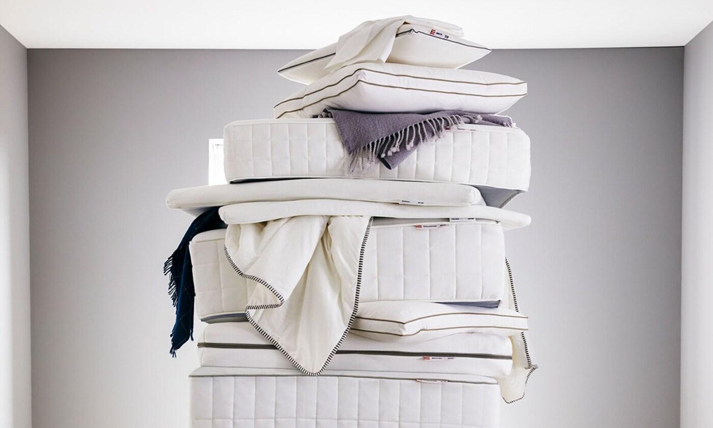 Mattresses, throws and pillows stacked atop one another