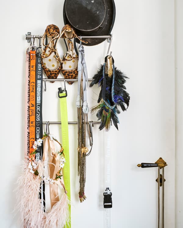 Metal kitchen rails on a white door store accessories including a top hat, leopard-print heels, necklaces and lanyards.