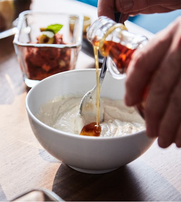 Miel en train d’être mélangé à du yoghourt et du tahini, pour faire une sauce.