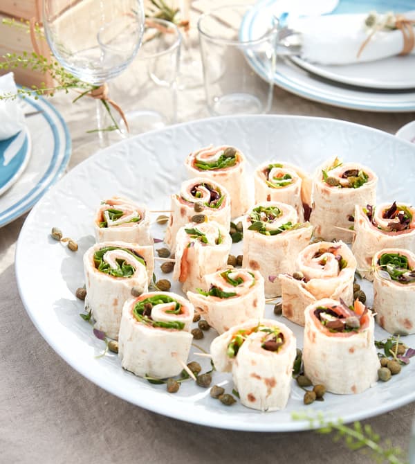 Mini wrap rolls with cured salmon and mustard sauce.
