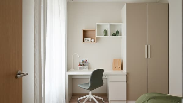 Minimalist workspace corner with a built-in desk, soft neutral tones, open shelving, and contemporary furnishings, creating a calm and functional area for studying or working within the modern apartment interior.