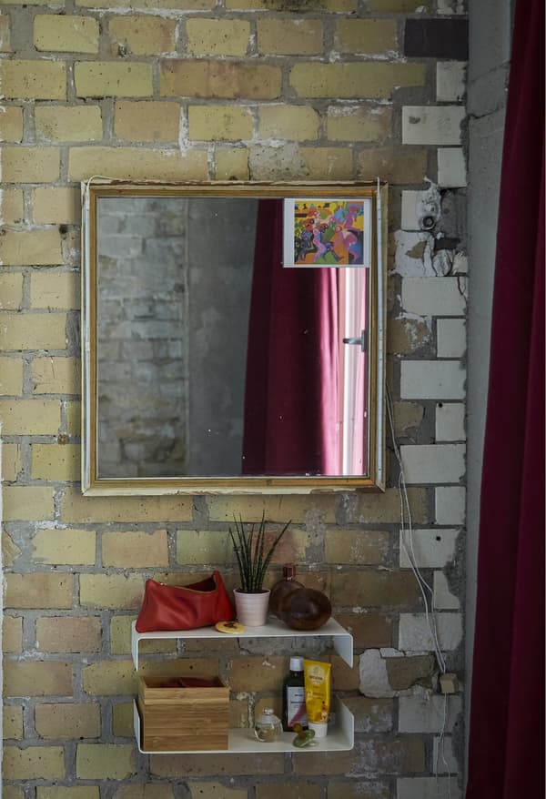 Miroir et tablettes sur un mur en briques.