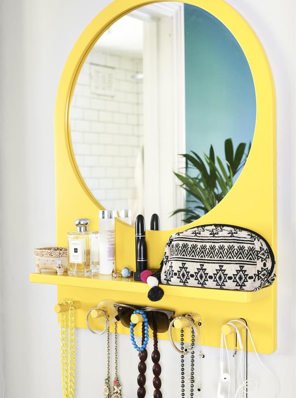 Miroir jaune avec tablette et patère intégrées.
