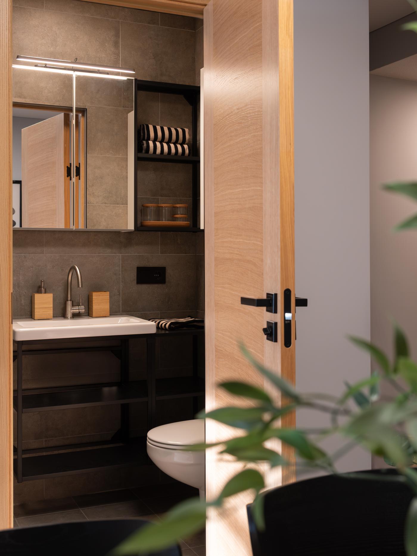 Modern bathroom with a dark grey wall-mounted vanity unit with a mirror cabinet above.