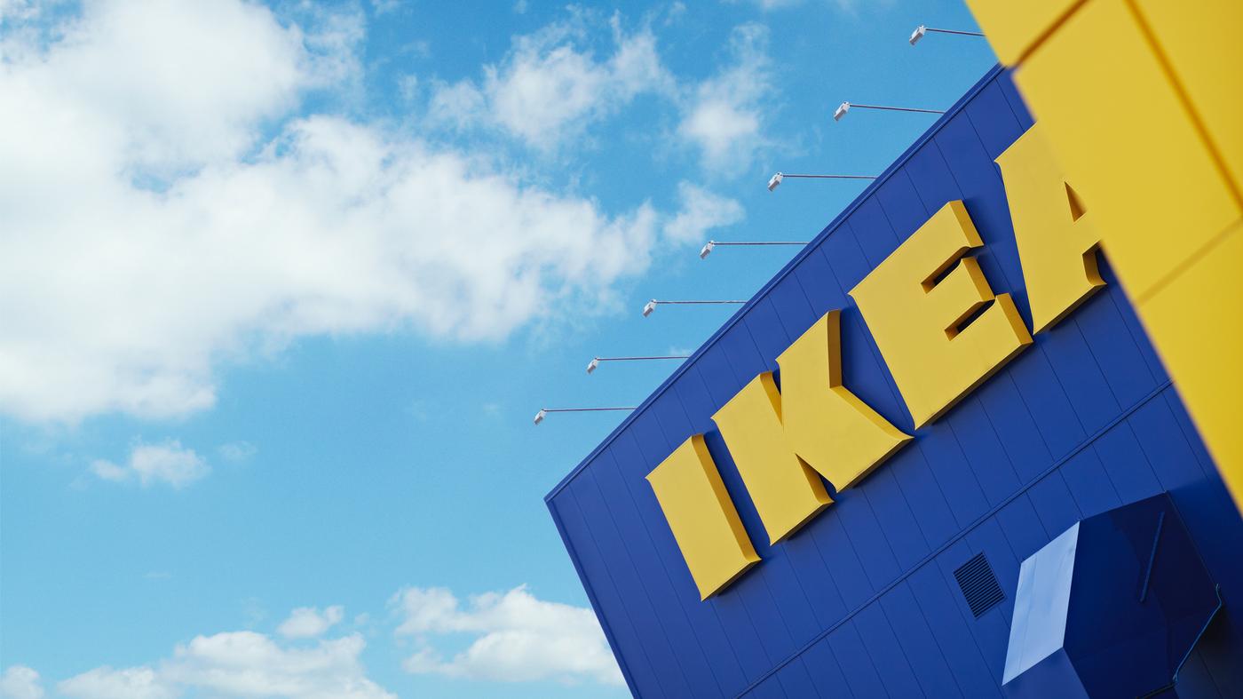 Modernes IKEA Einrichtungshaus mit ikonischer blauer Fassade und großem gelbem IKEA Logo unter strahlend blauem Himmel.