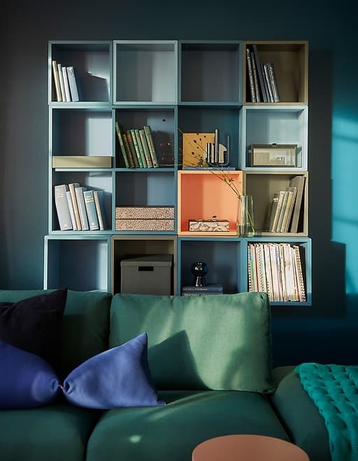 Modular cabinets like EKET from IKEA make it easy to build custom wall storage like this reverse L-shape against a corner. Shades of blue and grey tie the look together while keeping things interesting. A pop of light orange is playful, too.