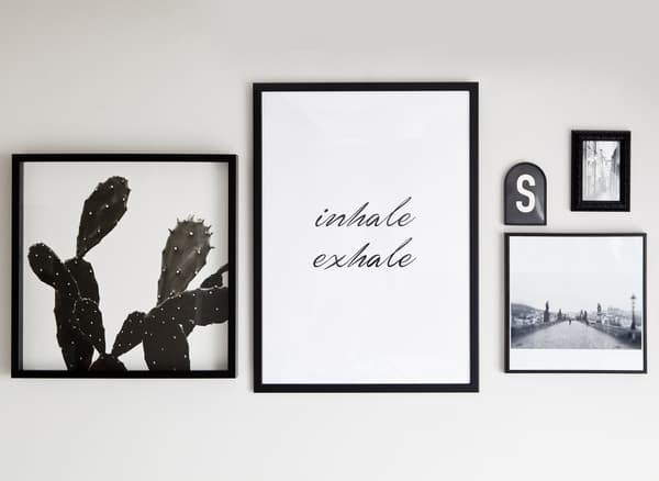 Monochrome prints and quotes in black frames.