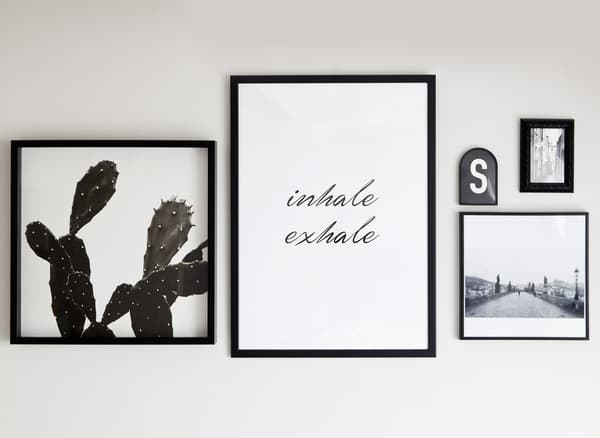 Monochrome prints and quotes in black frames.