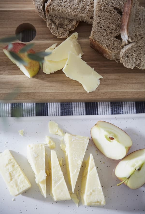 Morceaux de fromage, de pomme et de pain sur des planches à découper.