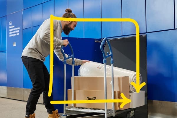 Moški jemlje svoje naročilo iz IKEA omarice.