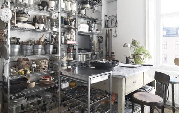 Mur de rangements ouverts métalliques dans une cuisine.