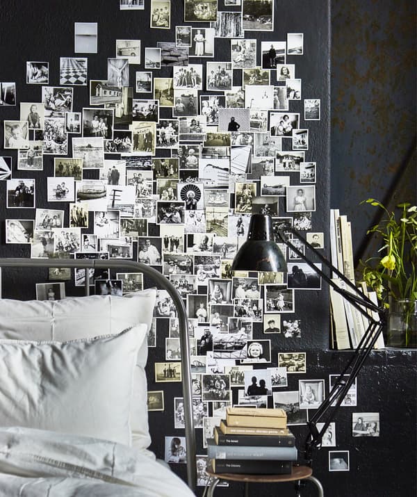 Mur d’une chambre à coucher recouvert de photos de famille en noir et blanc