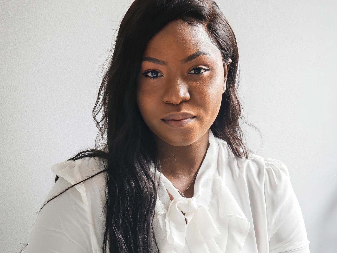 Na slici je Precious, izbeglica iz Nigerije i zaposlena u kompaniji IKEA Kanada, koja nosi belu bluzu.