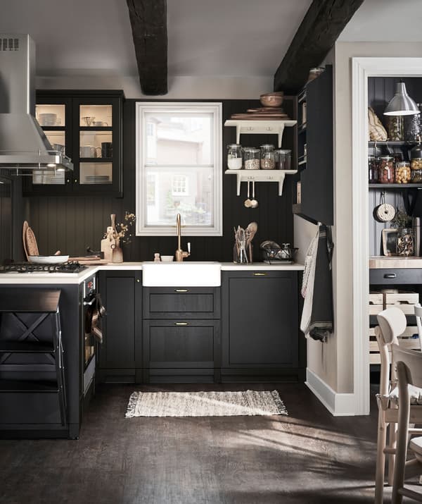 Neat, small, traditional-style kitchen with pantry and kitchen table; colour palette combination of dark and light surfaces.