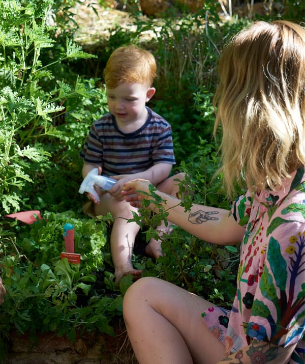 Nici aide son fil à arroser les plantes avec un pulvérisateur.